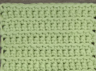 Close-up of green yarn worked in rows of Front Loop Single Crochet stitches