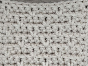 Close-up of yarn crocheted in the Basket stitch, showing alternating Back Loop Single Crochet ridges divided by vertical spike stitches.