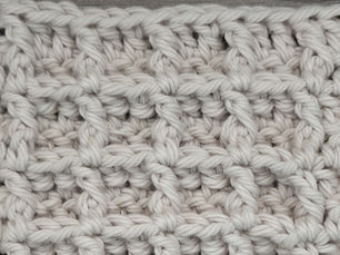 Close-up of yarn crocheted in the Waffle stitch, showing a raised grid of recessed square sections.