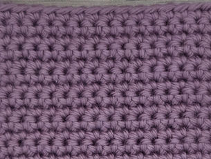 Close-up of purple yarn worked in rows of Single Crochet Stitches