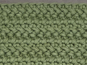 Close-up of yarn worked in rows of slanted Herringbone Double Crochet stitches