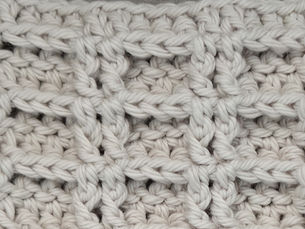 Close-up of yarn crocheted in the Double Waffle stitch, showing raised rectangular sections formed with Front Post Double Crochet stitches.
