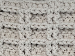 Close-up of yarn crocheted in the Double Waffle stitch, showing raised rectangular sections formed with Front Post Double Crochet stitches.