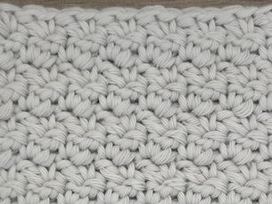 Close-up of light gray yarn worked in the Bud Pattern with small raised, bud like stitches.