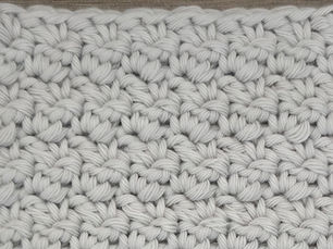 Close-up of light gray yarn worked in the Bud Pattern with small raised, bud like stitches.