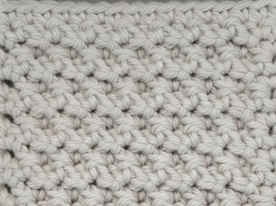 Close-up of yarn crocheted in the Raspberry stitch, showing staggered raised Front Post Single Crochet stitches.