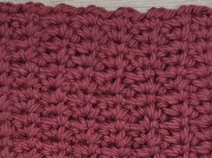 Close-up of yarn worked in the Spider STitch with paired Single Crochet stitches and small chain one spaces.