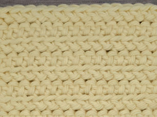 Close-up of yarn worked in rows of Front Loop Herringbone Half Double Crochet stitches.