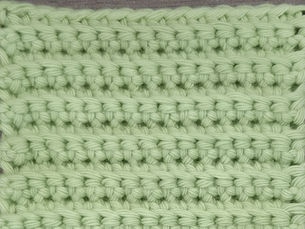 Close-up of green yarn worked in rows of Back Loop Single Crochet stitches