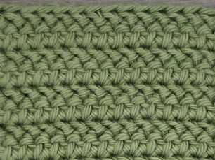 Close-up of yarn worked in rows of slanted Herringbone Half Double Crochet stitches.