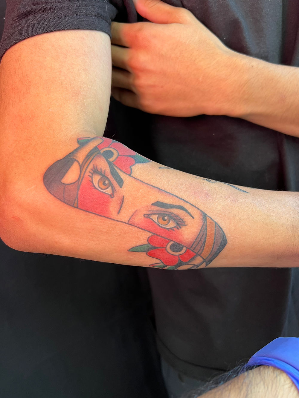 Tattoo of eyes and red accents on an arm