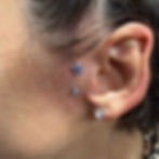 Ear with cartilage flower piercing and two lobe studs