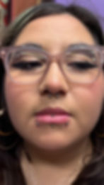 Person with glasses and facial piercings