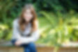 Image of the coach, Barbara Neufeld sitting outside smiling.