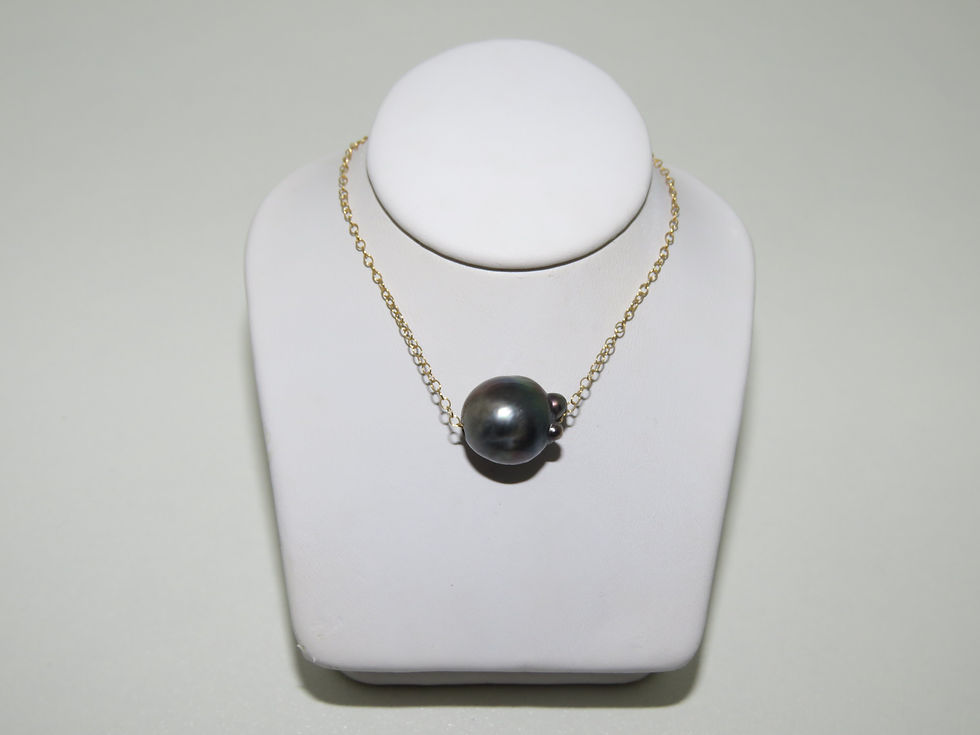 Gold chain Tahitian pearl necklace on white display on white background