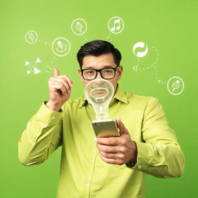 Man in a green shirt pointing upwards holds a magnifying glass over a smartphone. Icons float around his head on a green background.