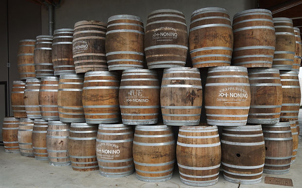 Fûts de bois portant les inscriptions Nonino, empilés dans la distillerie de Percoto.