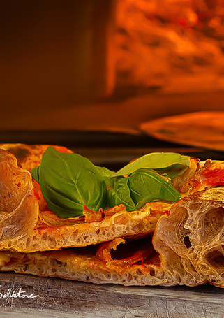 Handwerkliche Holzofenpizza mit luftigem Teig in La Corte Segreta in Casteau: ein Beispiel für kontrollierte Fermentation und traditionelle italienische Backkunst. Pizzeria nahe Soignies, Maisières, Lens und Mons.