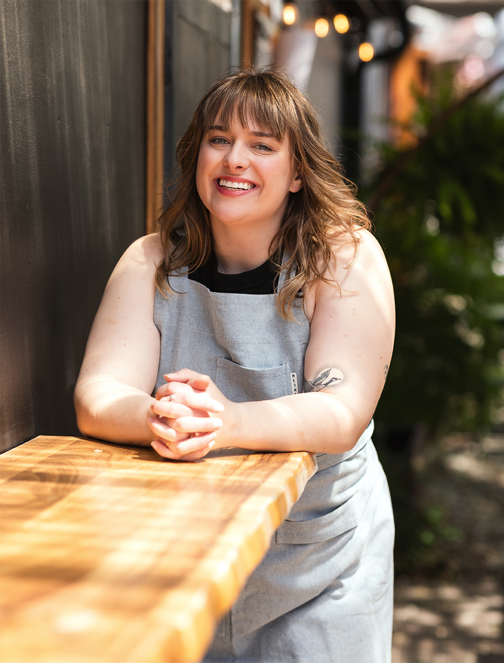 Woman smiling in apron outside