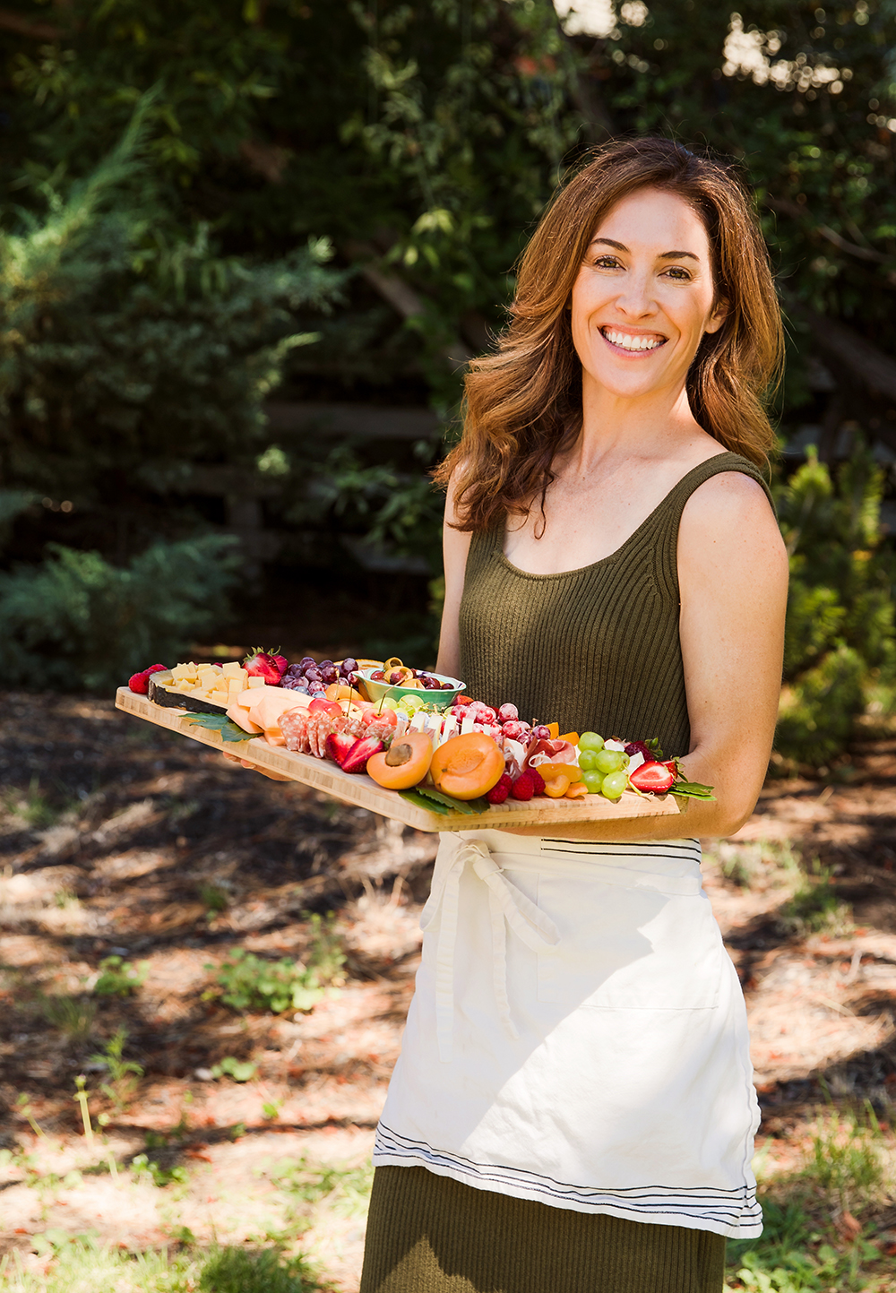 Woman standing outside holding charcuterie board