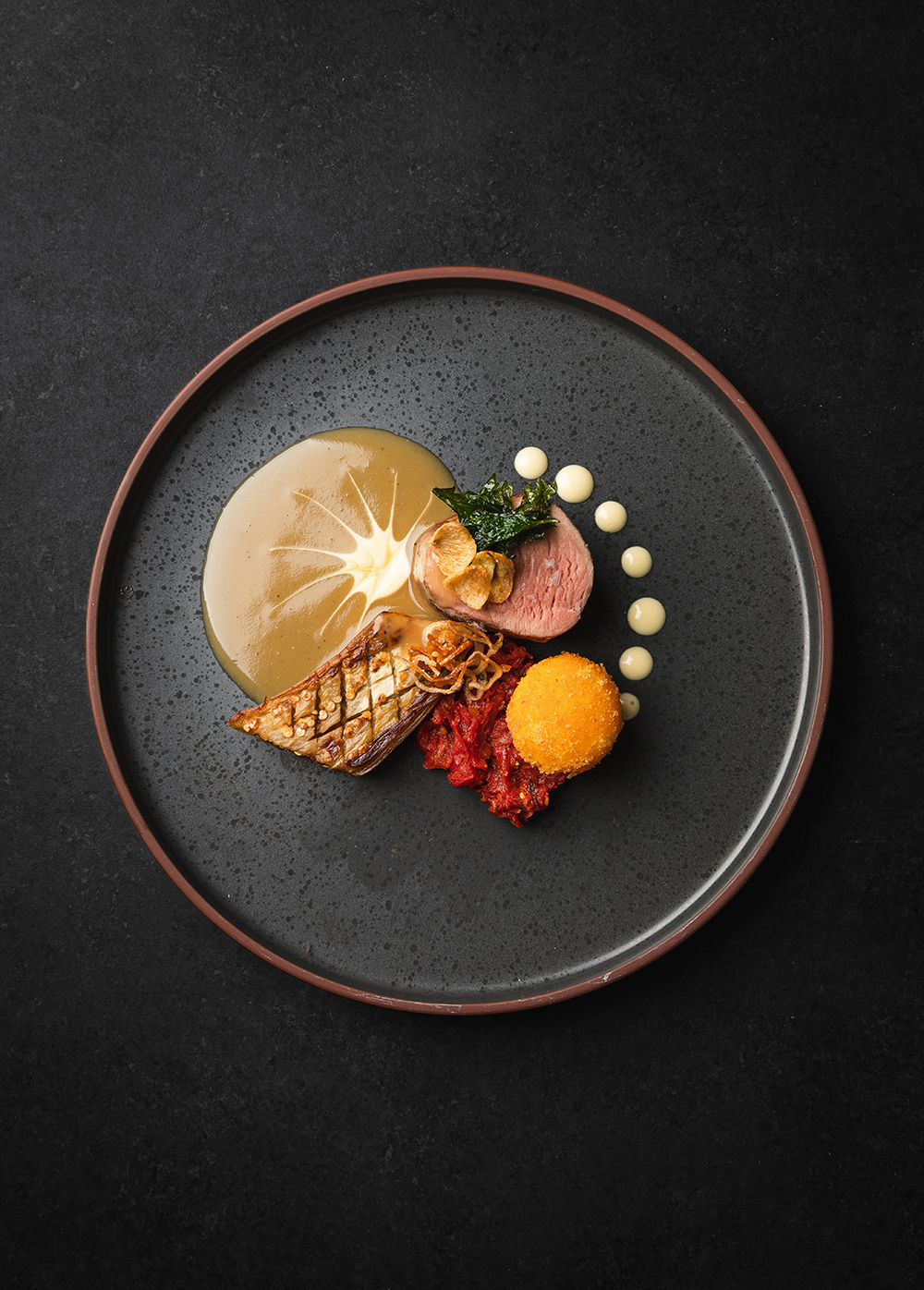 “Plated meat on a dark plate with garnish, studio lighting.”