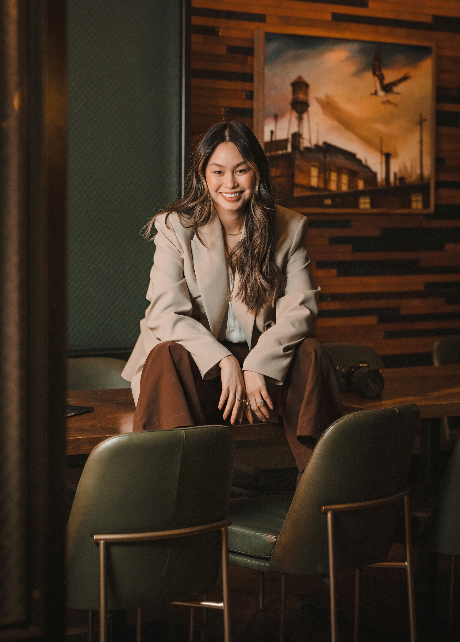 Woman in business attire sitting on desk