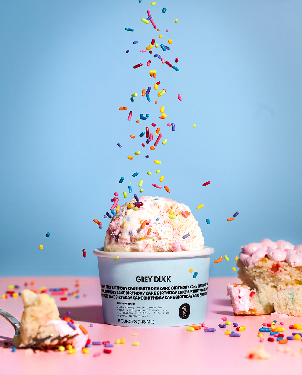 Ice cream in a cup with sprinkles pouring on it