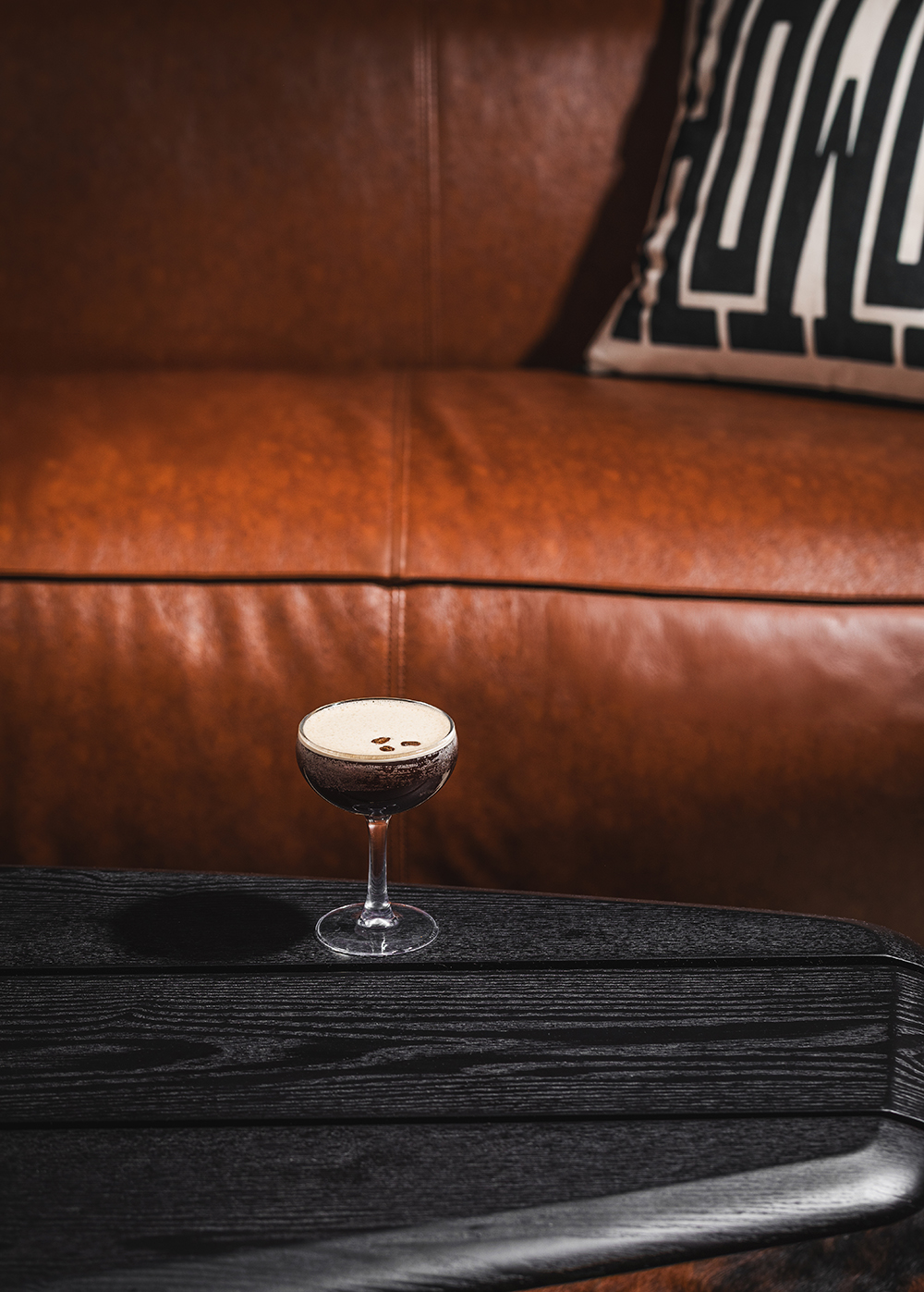 Espresso martini on table with brown couch
