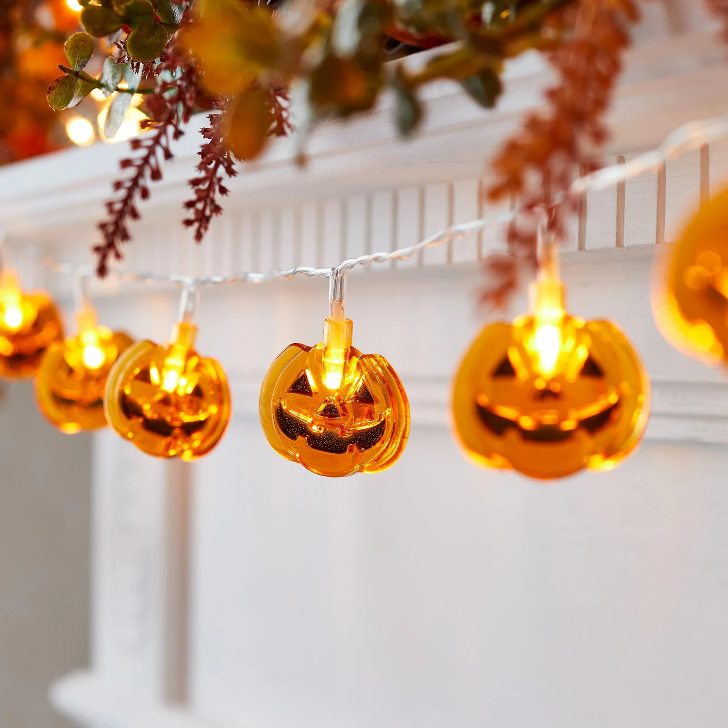 Making your home look elegant and spooky simultaneously isn’t rocket science — being heedful to small details and putting in some careful forethought can do the trick! As such, lighting shouldn’t be overlooked. Use interesting light fixtures to keep your home fairly dim and create a mysterious atmosphere. For instance: Source some pumpkin fairy lights and hang them in different places around the house
