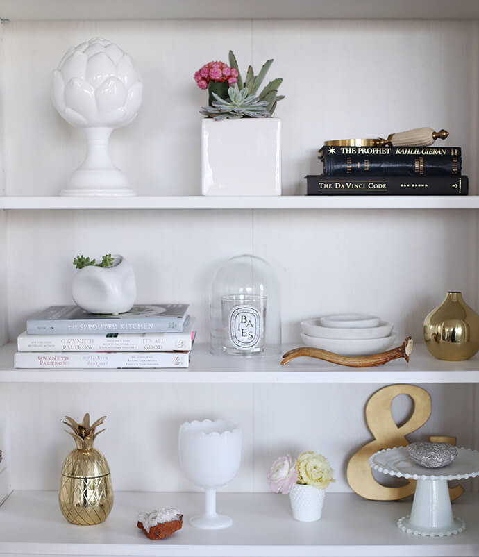Collect vases and pottery that fit your style but also match the colour palette. Go for a variety of shapes and sizes to create a chic finish — extra points for an arrangement of three! Pieces that look weathered and aged with lots of patina and texture will go perfectly with pieces that have a glossy and simple finish, creating an attractive contrast. Smaller bowls and vases can go on top of a stack of books, whilst larger pitchers and vases can make a statement and simplify an area with tons of smaller decor items.