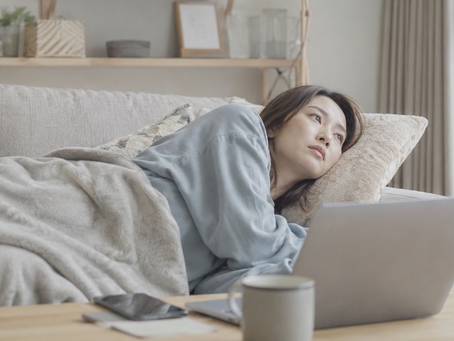 やる気が出なくソファーで横たわる女性