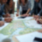 A group of developers looking at a table with a land plan on it