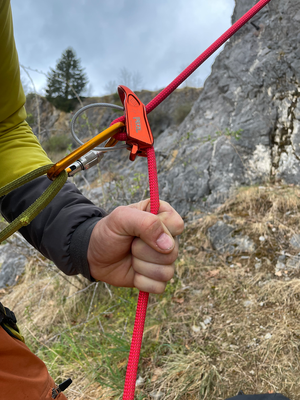 Hand sichert Kletterseil mit Tube-Gerät