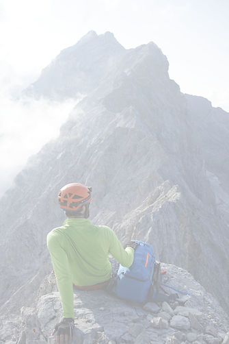 Bergsteiger lehnt sich zurück und genießt den Ausblick