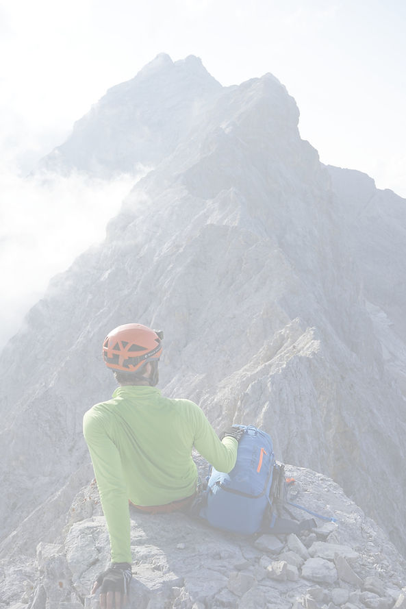 Bergsteiger lehnt sich zurück und genießt den Ausblick