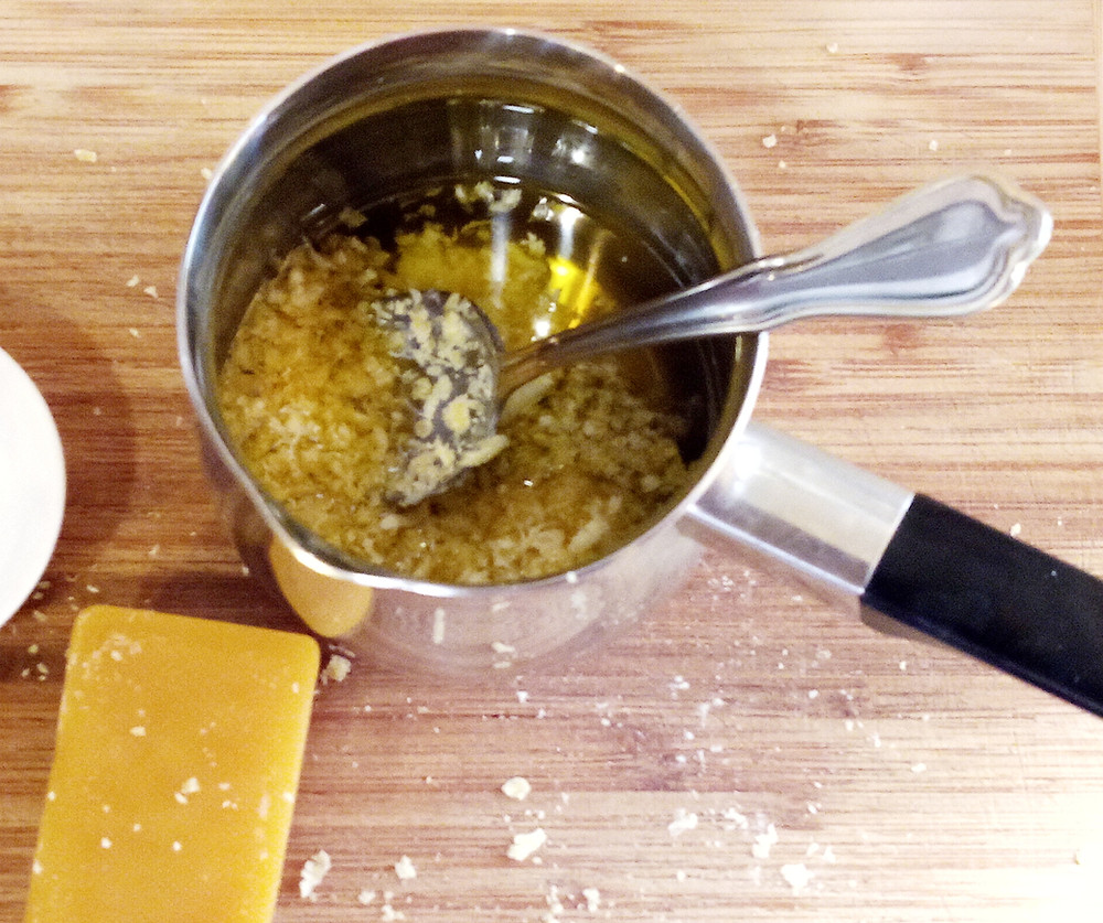 Melting beeswax, coconut oil into dandelion infused oil