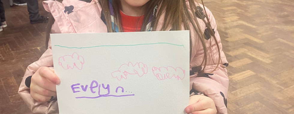 A Squirrel Scout holds up a drawing she's created