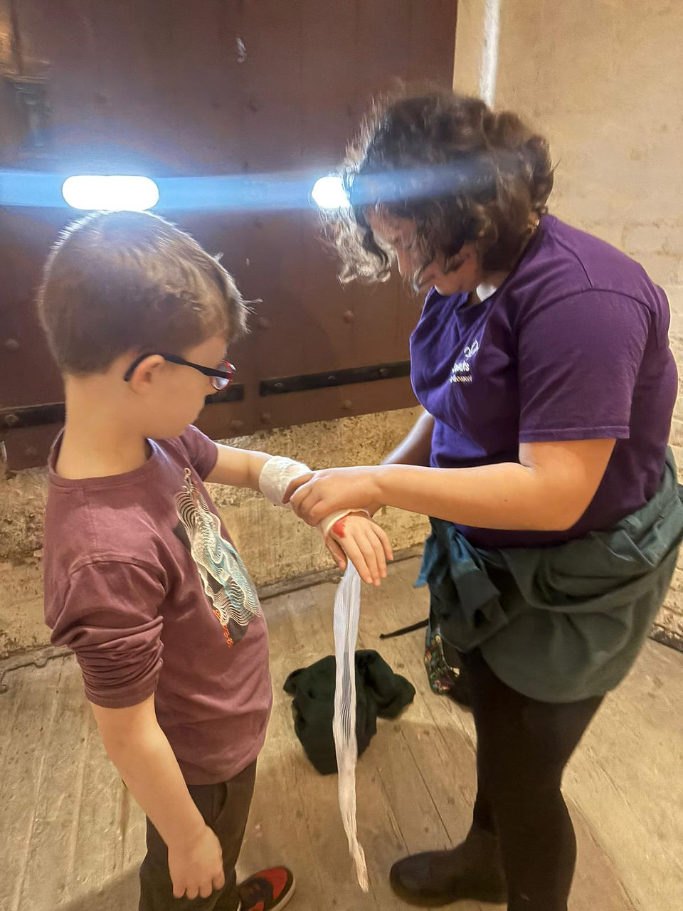 A Scout practices applying a bandage to a Cub