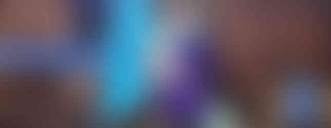 A Beaver Scout holds the group's Beaver flag. Beside her is a table, behind which is one of her leaders