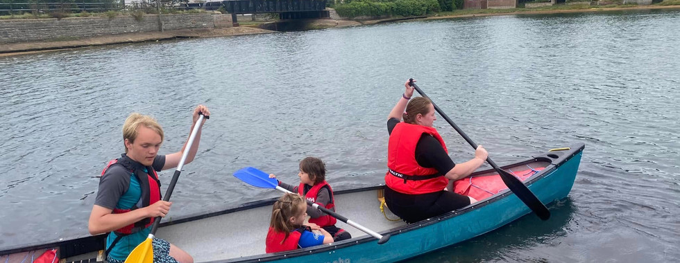 Two Squirrel Scouts sit in a canoe with two adults