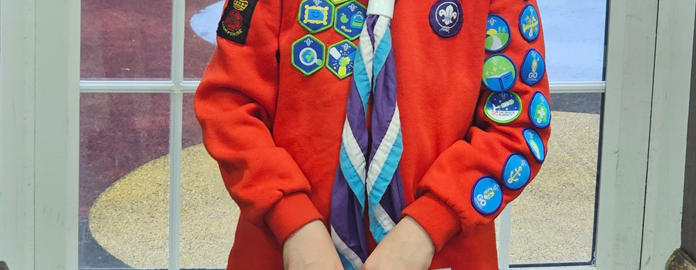 A Squirrel Scout holds a certificate celebrating her achieving all Squirrel badges