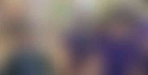 Two Cub Scouts wear WW2 era helmets, one an ARP warden's and the other an AFS volunteer's while between them another Cub wears a reproduction WW2 era gas mask