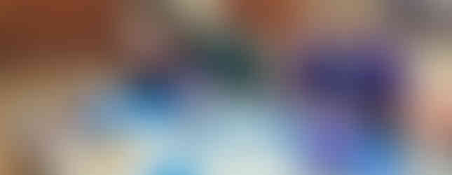 Two Cub Scouts sit at a table on which there are two eggs in jars of vinegar, metal takeaway trays with vinegar and pennies in, a paper towel with drying pennies on and a piece of paper next to pencils which is covered in pencil shavings