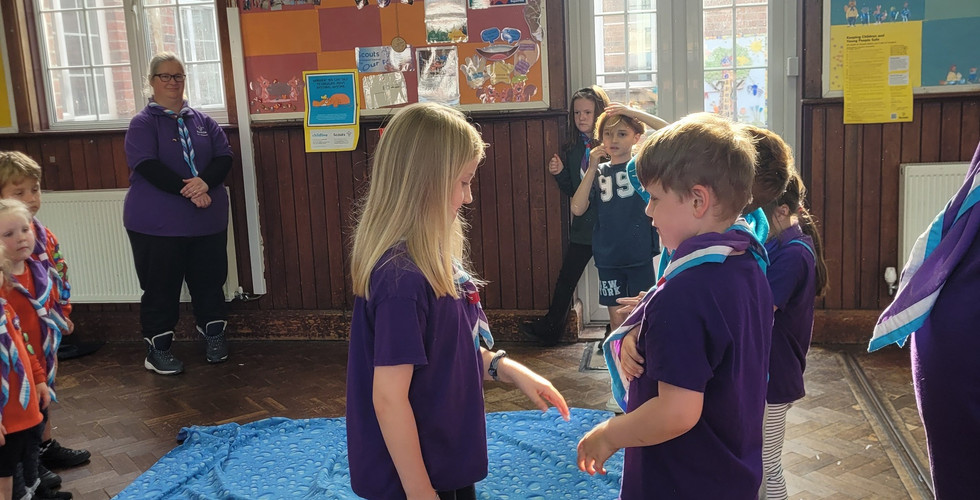 A new Cub Scout shakes hands with members of her group