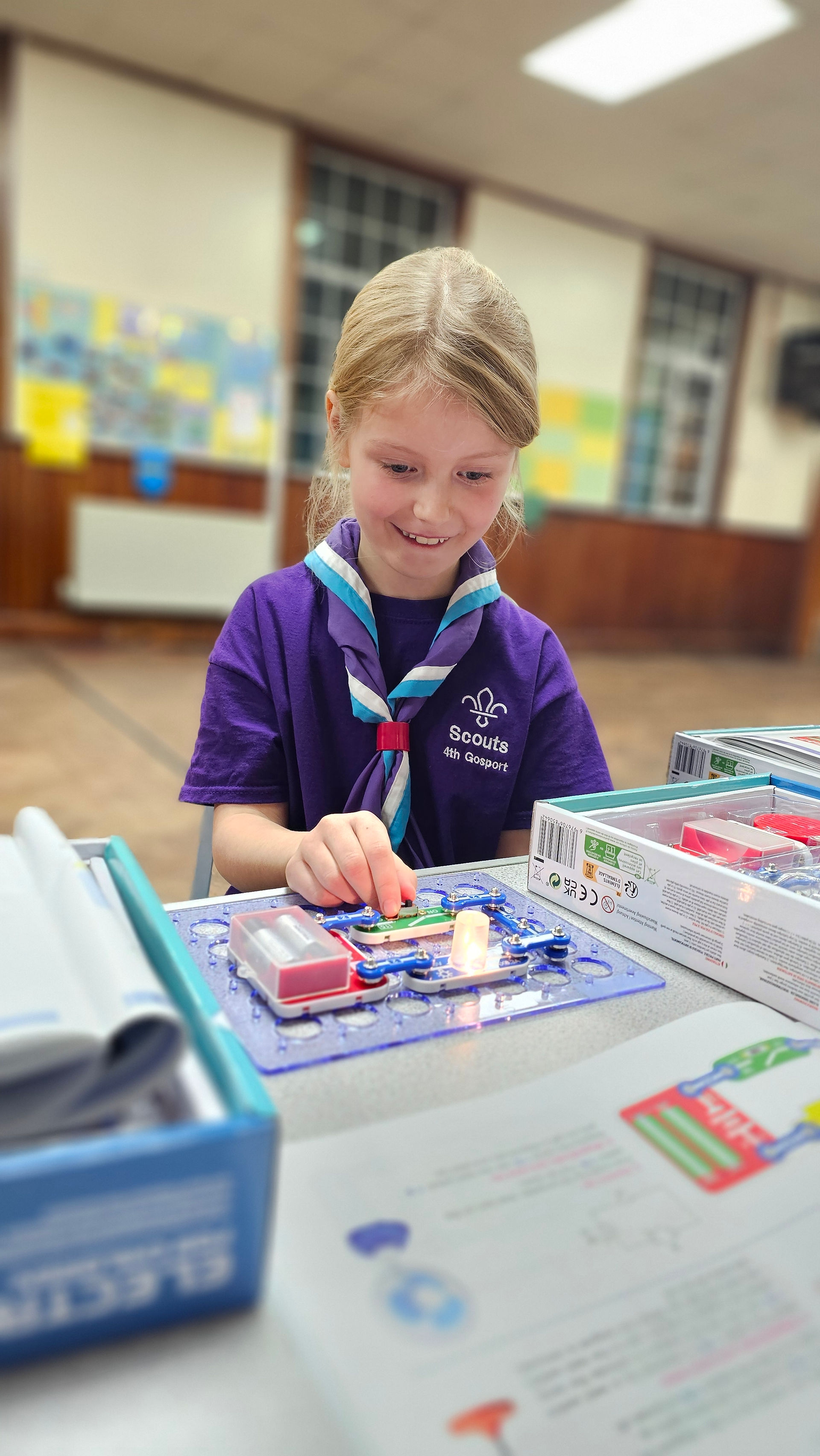 A Cub Scout uses a kit to create an electronic circuit
