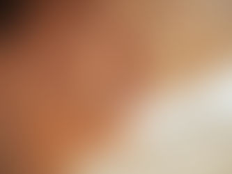 Close-up of a woman's face in profile, sunlight filtering through a straw hat casts patterns on her skin, creating a serene mood.