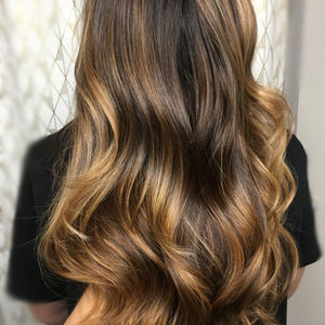 Hand painting of brunette hair with blonde highlights