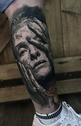 Realistisches 3D-Tattoo eines Frauenporträts mit Hand im Gesicht und Jerry-Figur – gestochen von Janosch im Inkwerk Bern Tattoo Studio