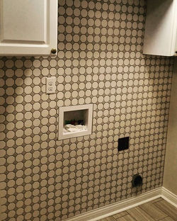 Behind the washer and dryer