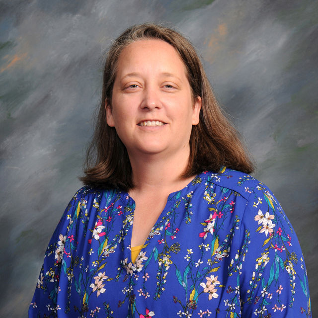 Woman with shoulder-length hair in a blue floral top